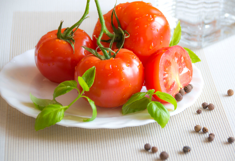 Tomato merah segar dipotong separuh di atas meja kayu untuk penjagaan kulit wajah