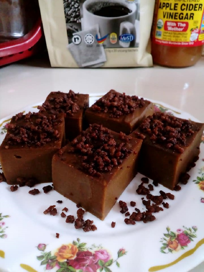 Sekeping kuih kole-kole kacang yang dipotong berbentuk segi empat dan ditabur dengan tahi minyak.