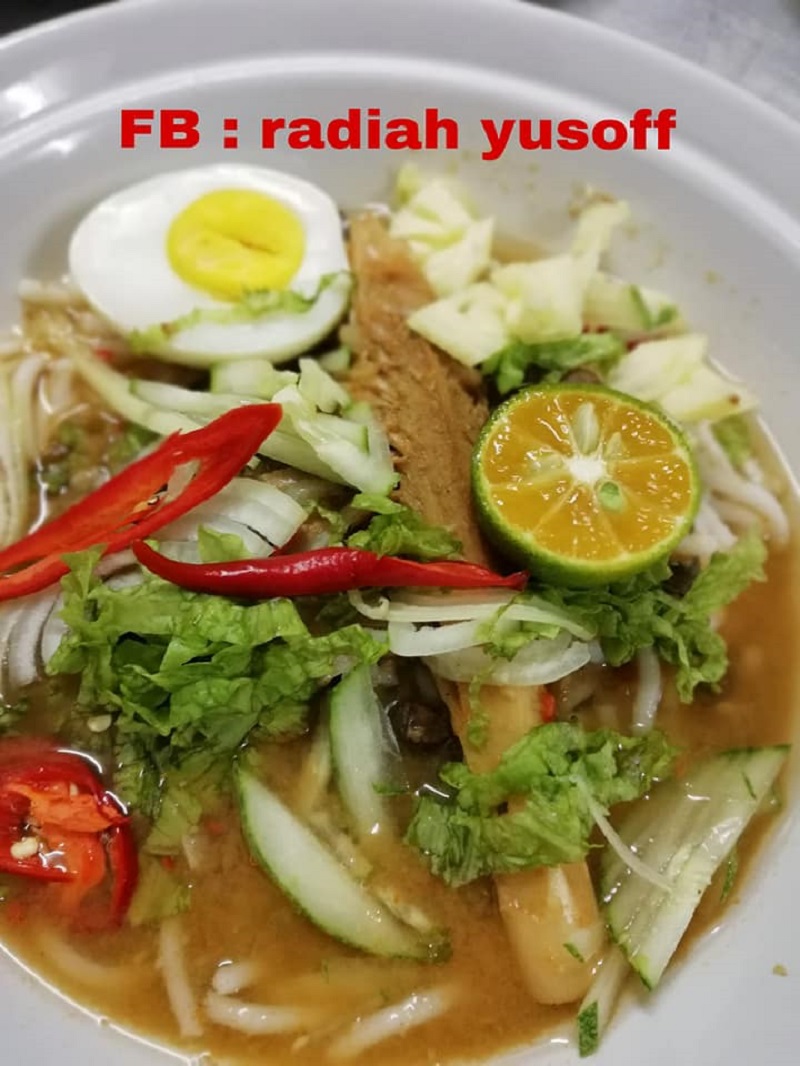 Sebiji mangkuk berisi laksa Penang dengan kuah, mi, ulaman dan telur rebus.