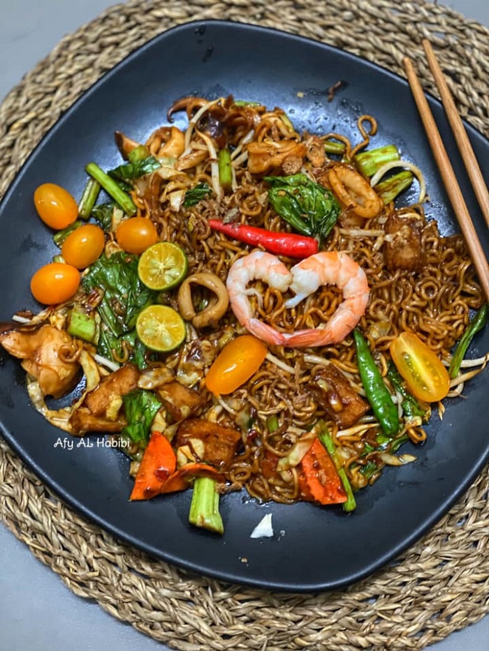 Gambar hidangan maggi goreng seafood dengan udang, sotong dan sayur-sayuran.