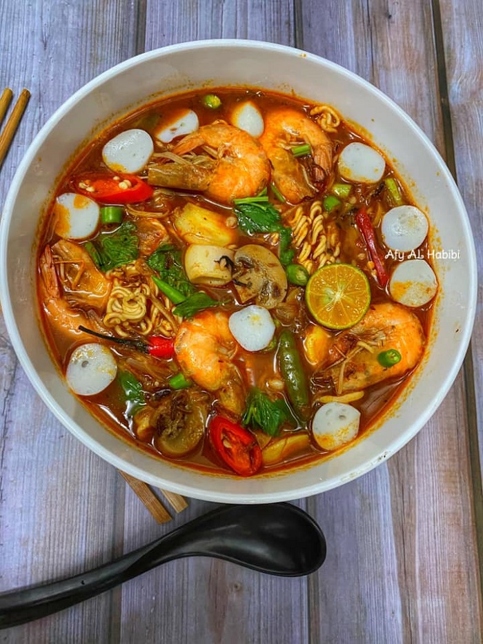 Se pinggan maggi kari tomyam yang baru siap dimasak dengan sayuran, ayam dan makanan laut.