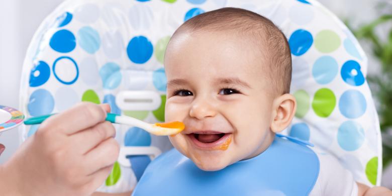 Bayi sedang makan makanan pejal dalam mangkuk kecil bersama ibu