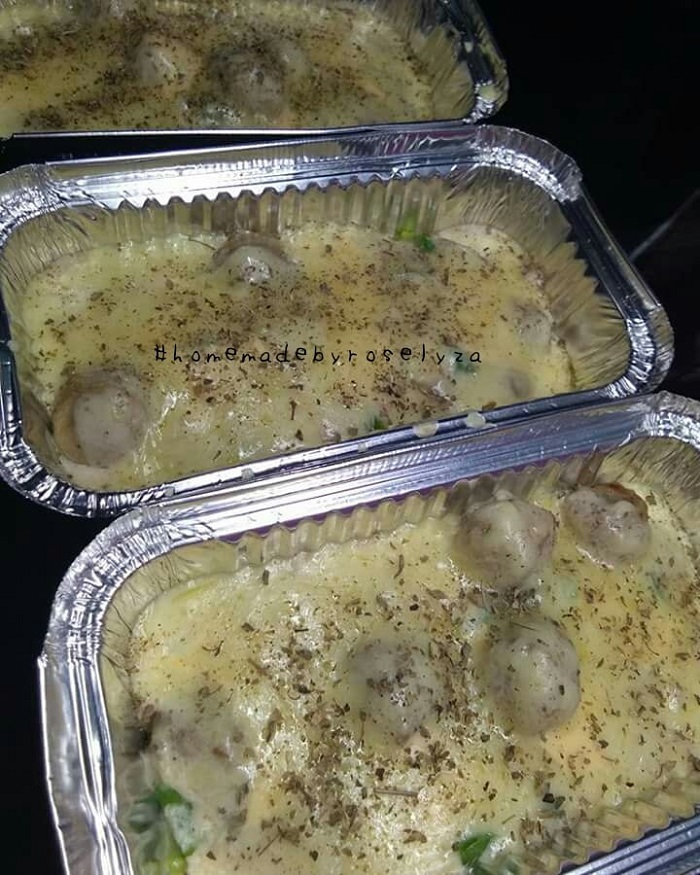 Hidangan meatball carbonara cheese yang meleleh dan berkrim di dalam bekas pembakar.