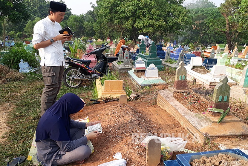 Gambar suasana umat Islam menziarahi kubur di tanah perkuburan.