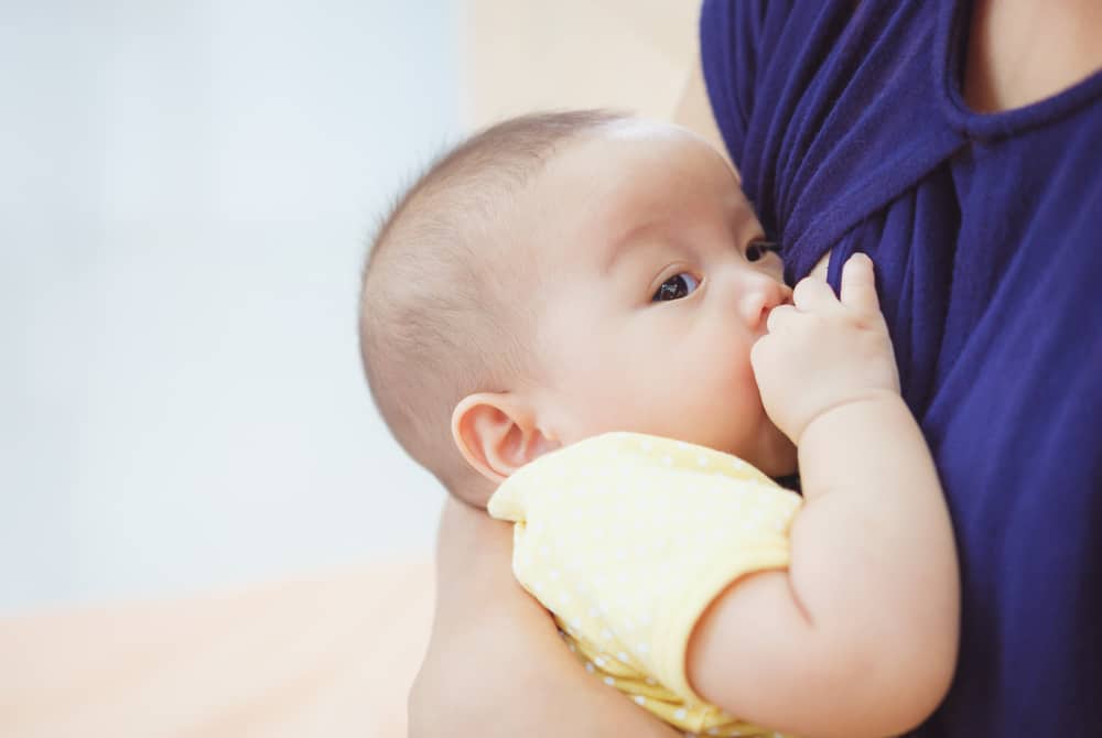 Gelanggang wanita sedang menyusukan bayi sebagai gambaran makanan tambah susu badan.