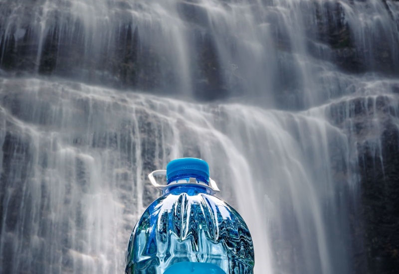Botol air mineral dan air minuman berwarna telus diletakkan bersebelahan untuk perbandingan.