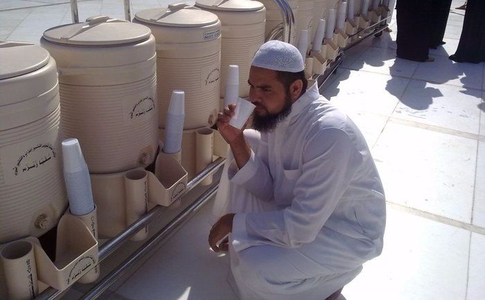 Tong plastic putih berisi Air Zamzam dengan tulisan Arab, melambangkan air yang suci dan berkhasiat.