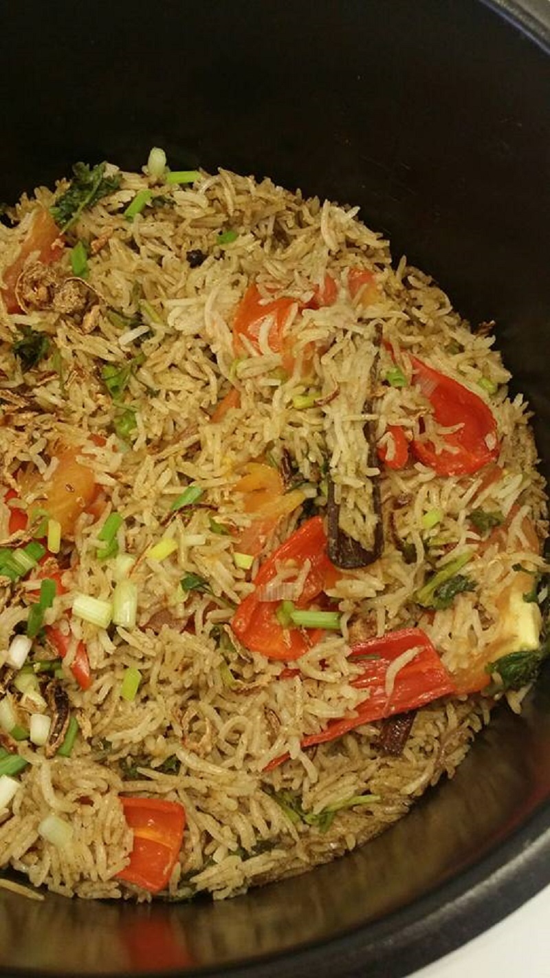 Sepinggan hidangan nasi bukhari berempah dengan taburan bawang goreng dan ayam bakar.