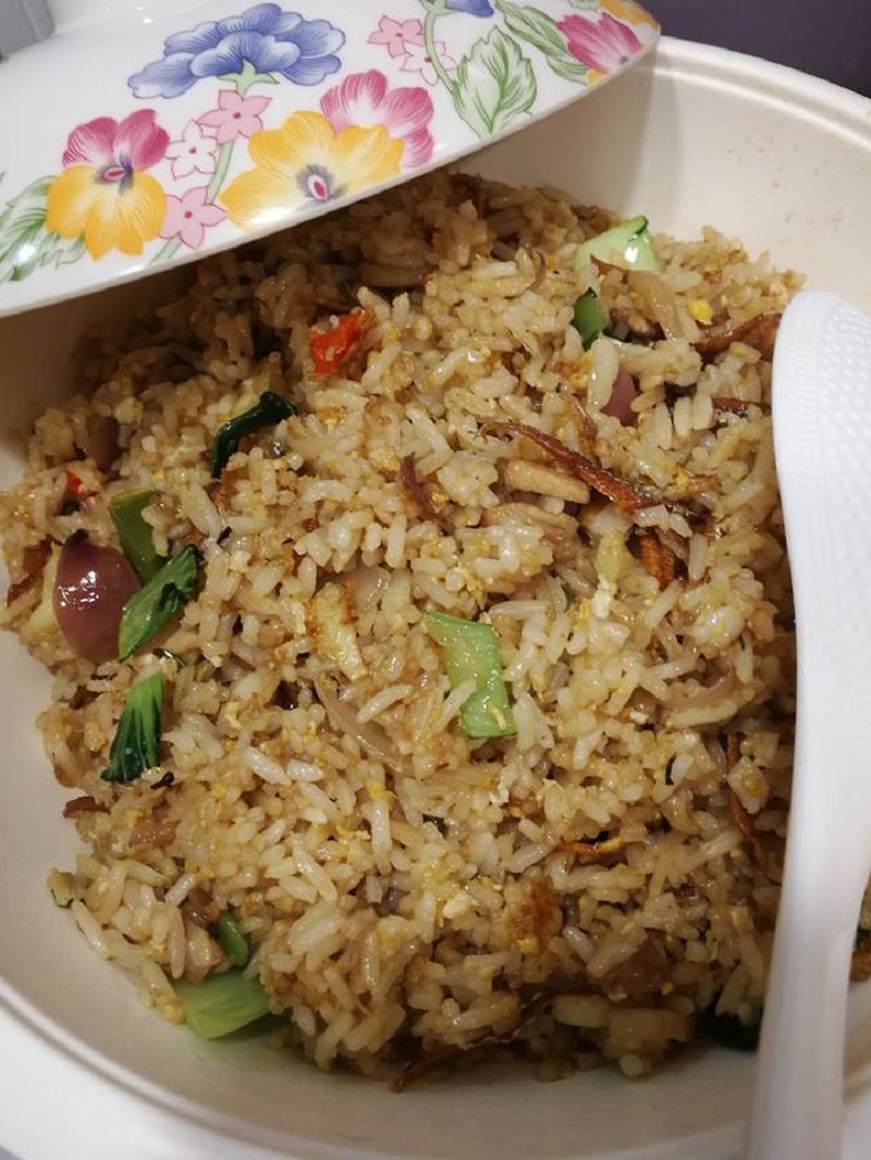 Nasi goreng kampung pedas dihidangkan bersama hirisan timun dan keropok.