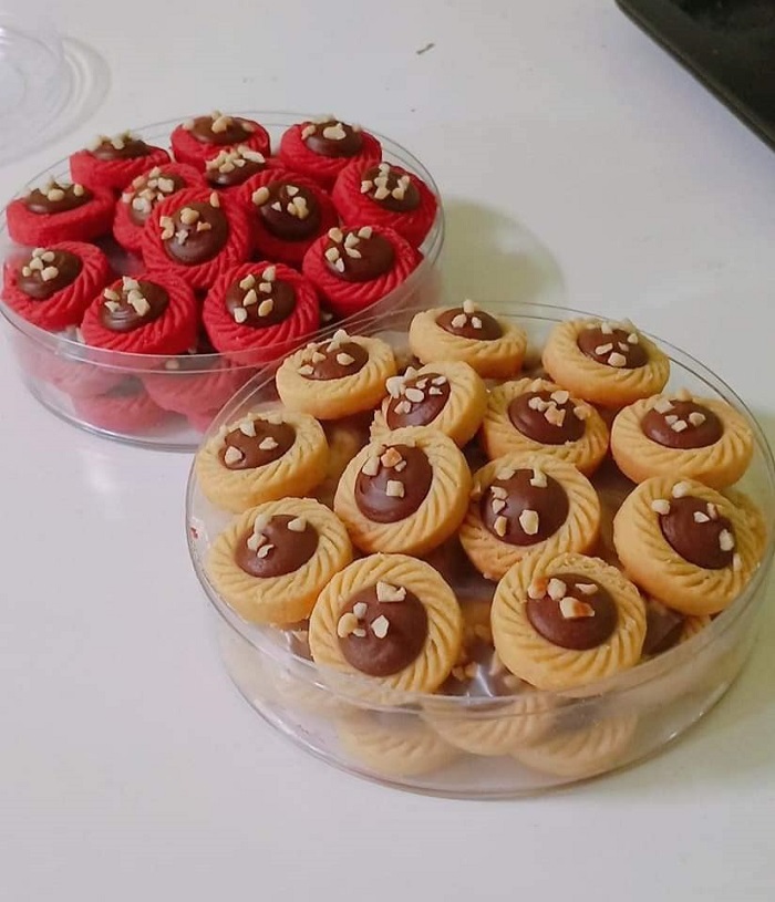 Imej tart Nutella berbentuk bulat dengan inti coklat dan taburan badam.
