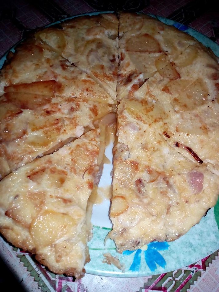 Omelette potato keemasan di atas piring, hidangan telur goreng bersama kentang dan bawang.