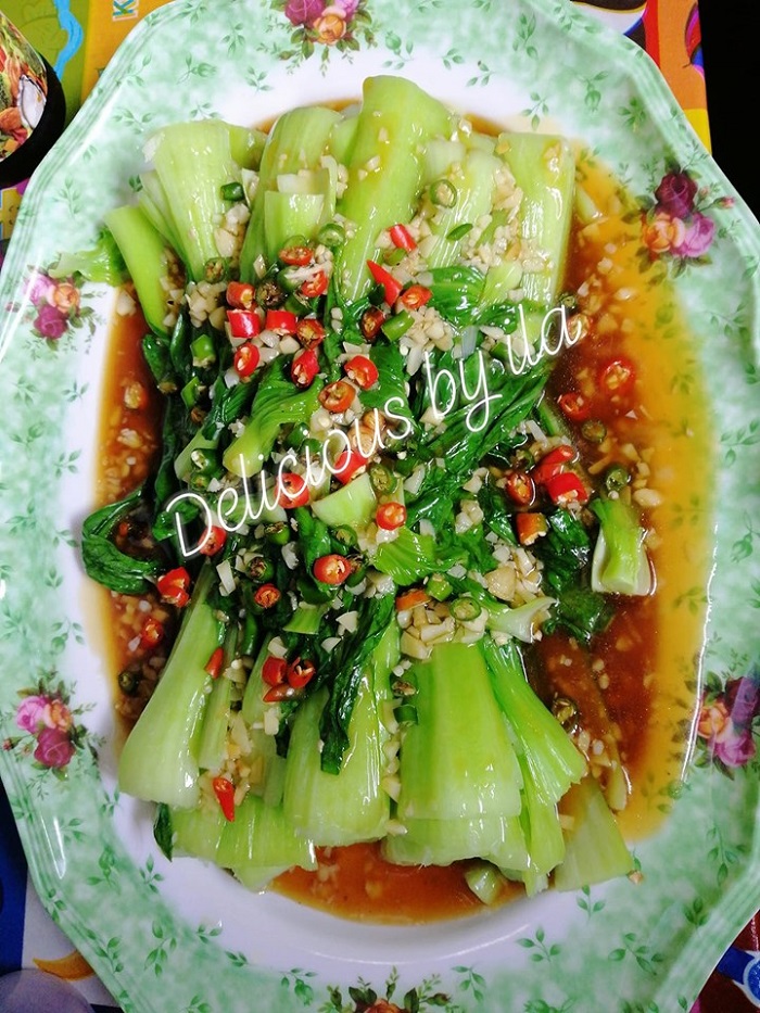 Sayur sawi bunga atau pak choy dimasak dengan sos tiram di atas pinggan.