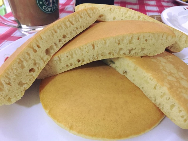 Gambar pan cake extra fluffy yang masak keemasan disusun di atas pinggan.