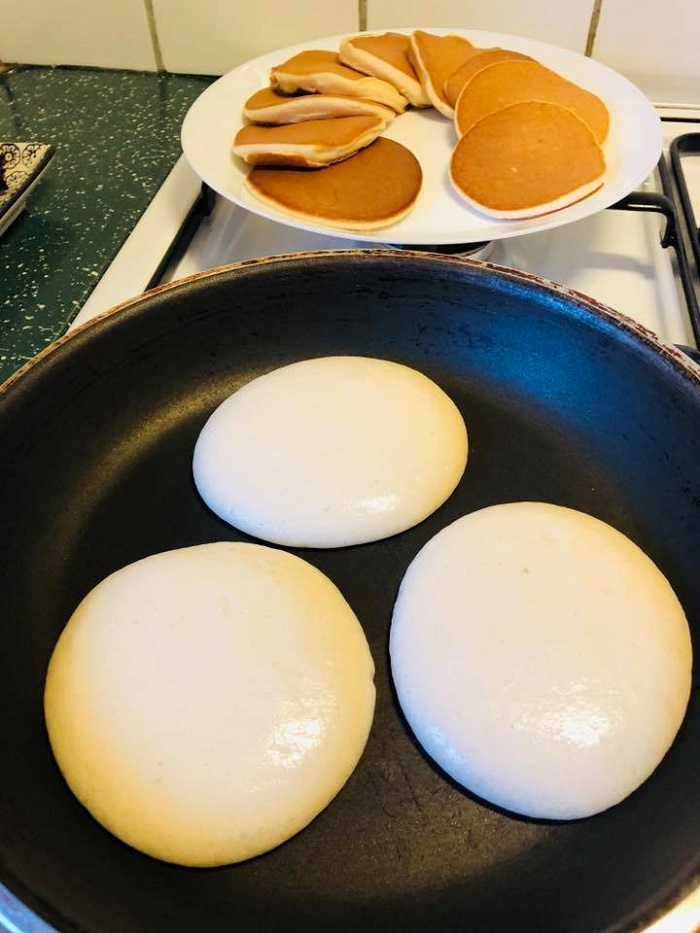 Gambar pancake gebu yang masak dengan kekuningan dan menyelerakan di atas pinggan.