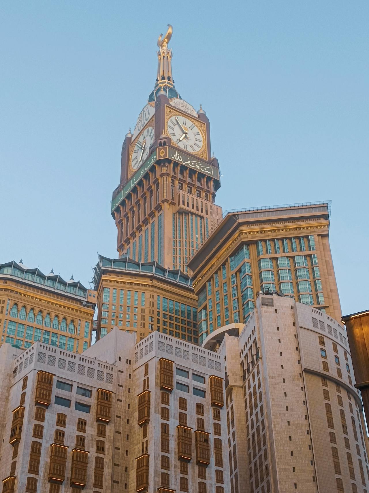 Segelas air zamzam dengan latar belakang Kaabah sebagai simbol air suci dalam Islam.