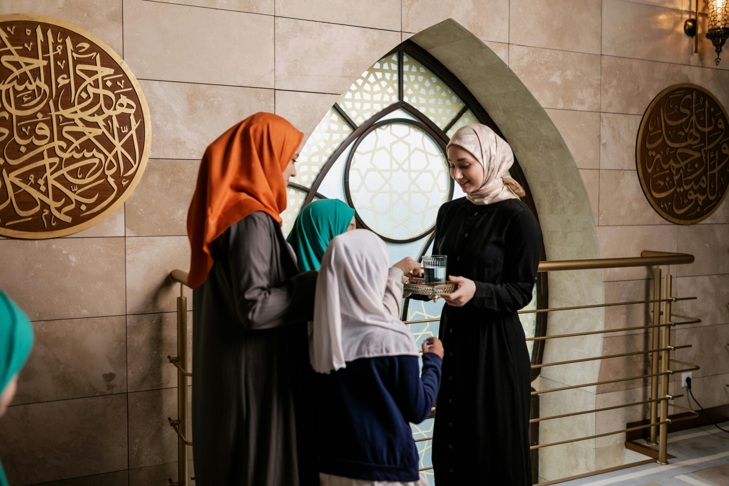 Wanita bertudung beige memandang ke arah masjid dari belakang.