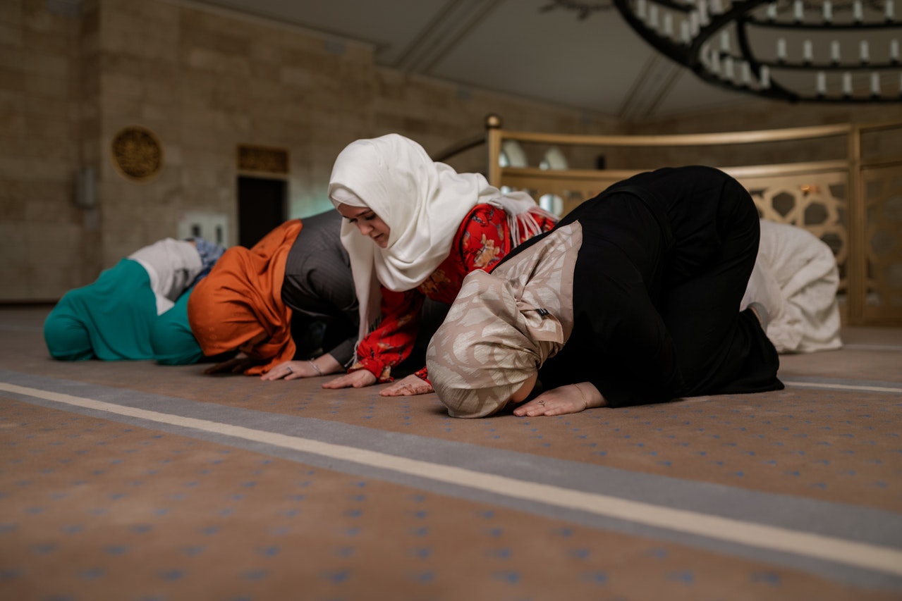 Jemaah lelaki mendirikan solat berjemaah di dalam masjid yang luas.