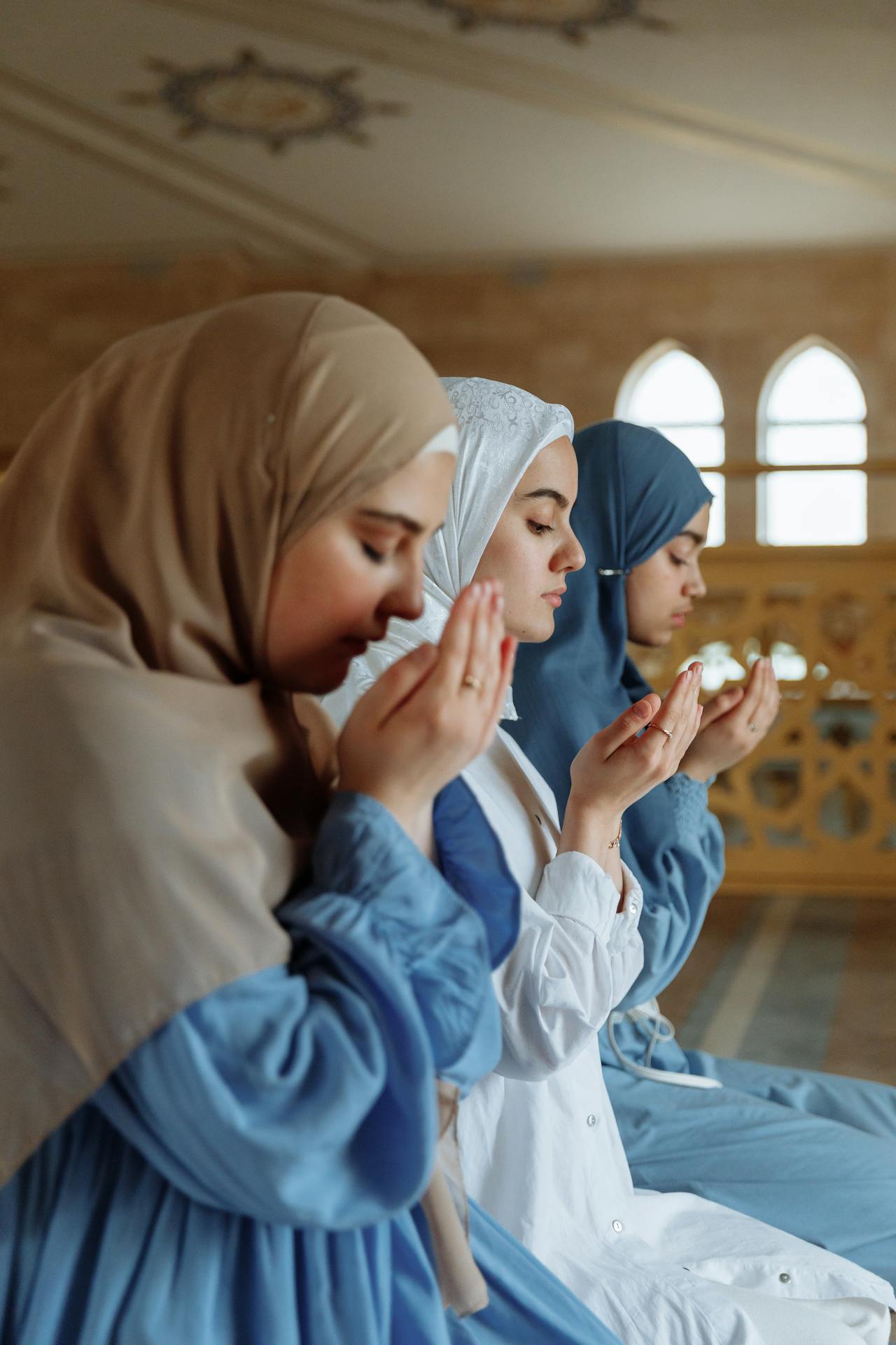 Ilustrasi seorang muslimah sedang berdoa dengan tenang, melambangkan ketekunan dalam beribadah.
