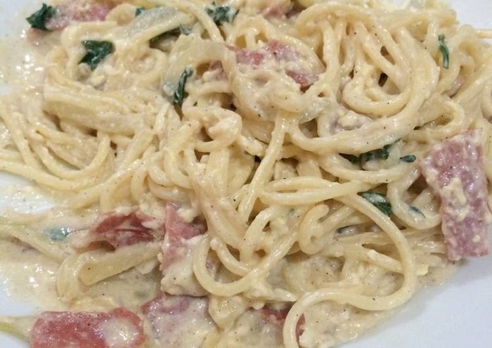 Sepinggan spaghetti carbonara dengan cendawan dan sosej yang sedang dan membangkitkan selera.