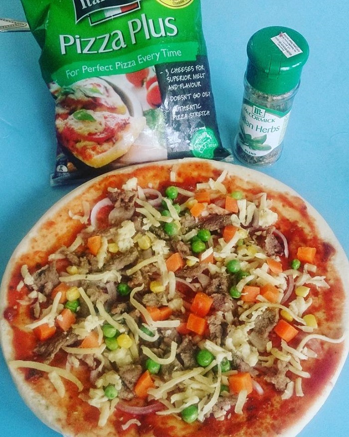 Pizza yang dibakar dengan topping keju dan sosej
