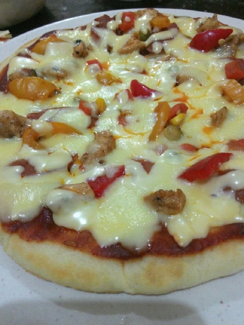 Gambar pizza yang dimasak menggunakan kuali dengan topping cheese, ayam dan cendawan