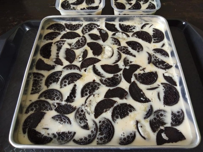 Bahan puding Oreo dilenyek dan disusun dalam bekas