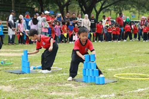 Kanak-kanak sedang menyertai acara sukaneka di padang sekolah