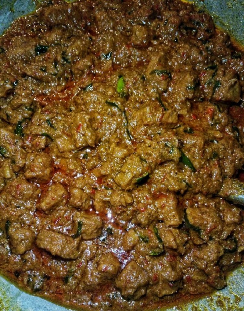 Hidangan rendang daging pedas yang dimasak dengan santan dan rempah.