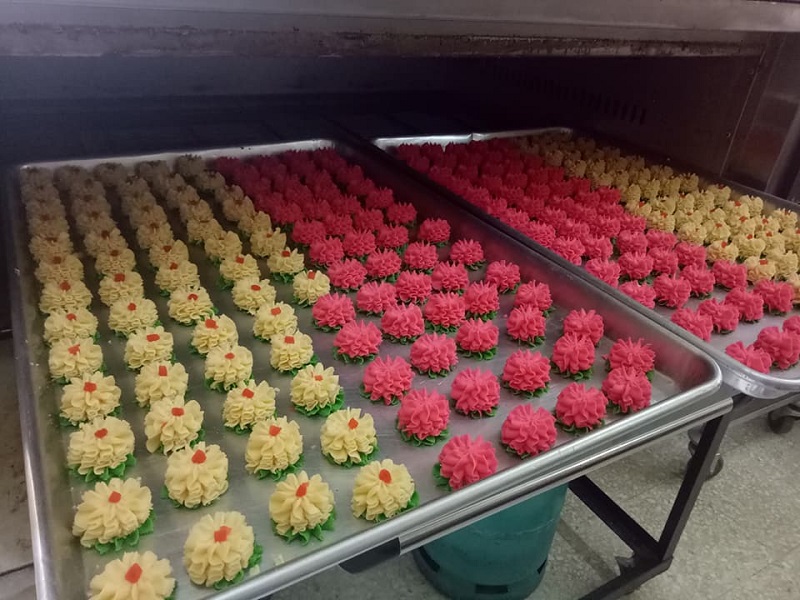 Biskut dahlia berwarna-warni yang cantik diletakkan di atas pinggan untuk dihidang.