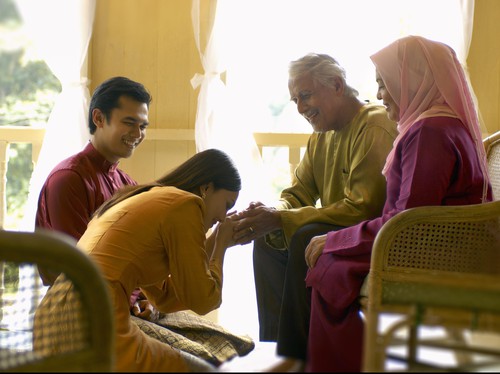 Seorang ibu bapa memeluk dan mencium anak kecil mereka dengan penuh kasih sayang.