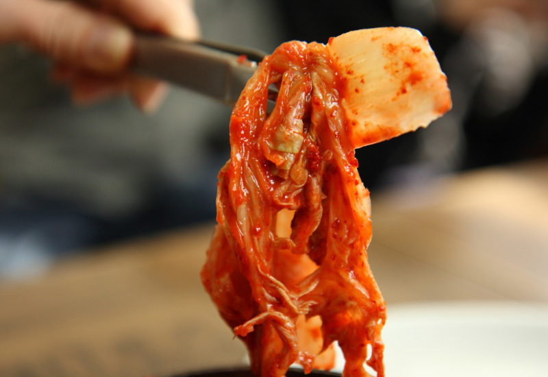 Mangkuk berisi kimchi sayur kobis napa yang berwarna merah akibat serbuk cili.