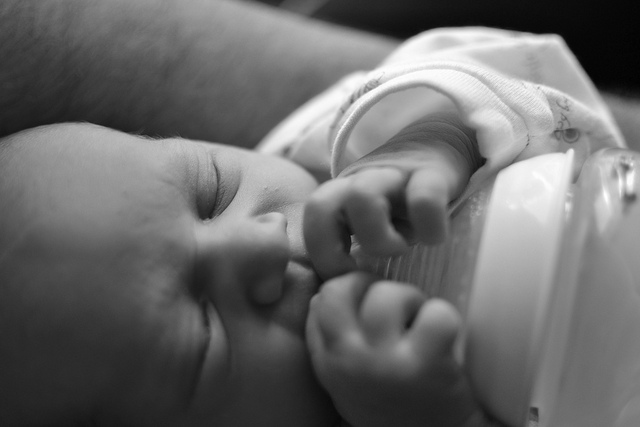 Gambar susu ibu dan botol susu bayi yang melambangkan pemilihan susu terbaik untuk tumbesaran bayi.