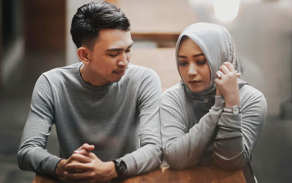 Gambar pasangan suami isteri bermasalah dengan emosi wanita yang murung memegang telefon bimbit