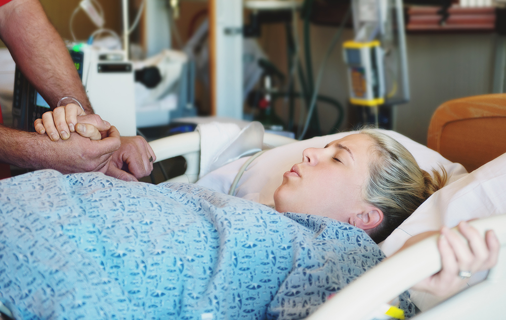 Wanita sedang bersakit dalam proses bersalin di hospital.