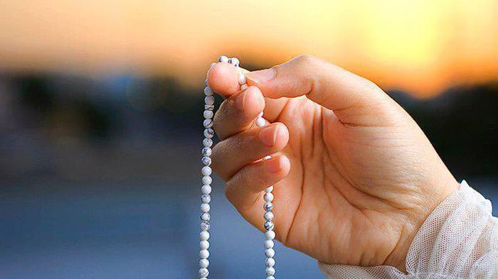 Wanita muslimah sedang berzikir menggunakan tasbih